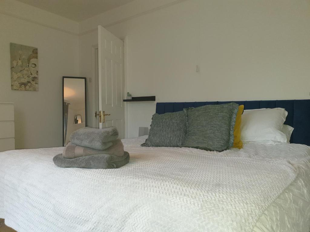 een slaapkamer met een wit bed en een spiegel bij Mulberry House Excellent central location Courtyard garden 3 Bedrooms sleeps up to 6 Parking in Exeter