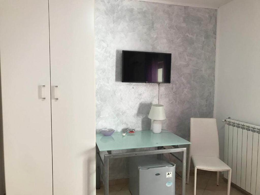 a desk with a lamp and a tv on a wall at Busalacchi B&B in Mondello