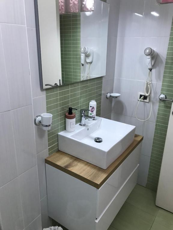 a bathroom with a white sink and a mirror at Busalacchi B&B in Mondello
