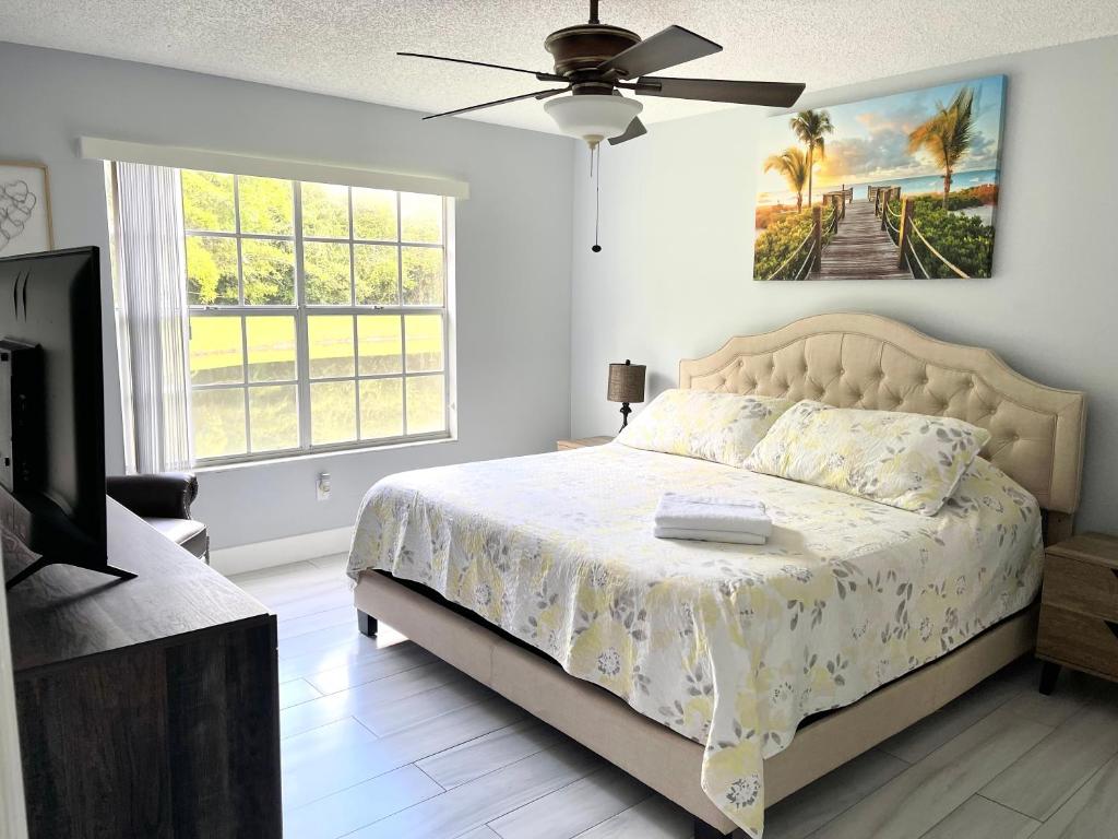 Un dormitorio con una cama y un ventilador de techo. en Great Lovely Family Apartment close Disney, en Kissimmee
