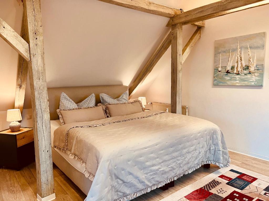 sypialnia z dużym łóżkiem i drewnianymi belkami stropowymi w obiekcie Auszeit w mieście Große Mühle