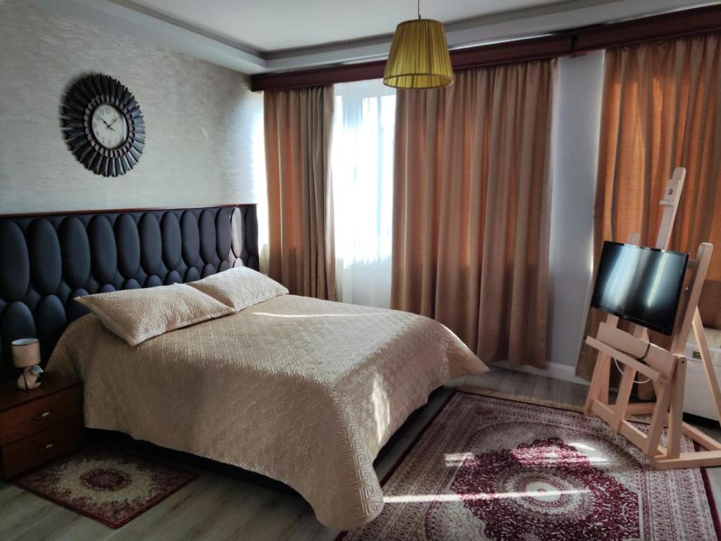 a bedroom with a bed and a television in it at Hotel Blue Eye in Korçë