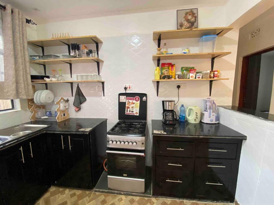 a kitchen with a stove and a counter top at Zen House in Kakamega
