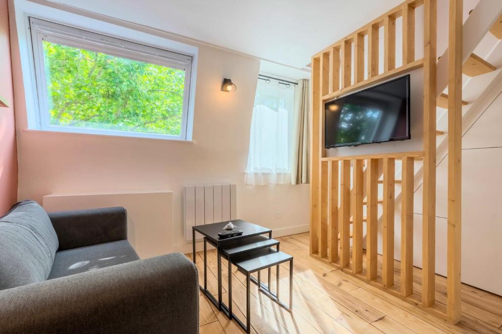 un salon avec un canapé et une télévision dans l'établissement Little duplex in République beaux arts, à Lille