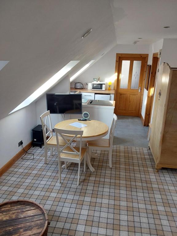 a kitchen and dining room with a table and chairs at Top Floor Flat Ceol Na Mara (Music of the Sea) in Rosemarkie