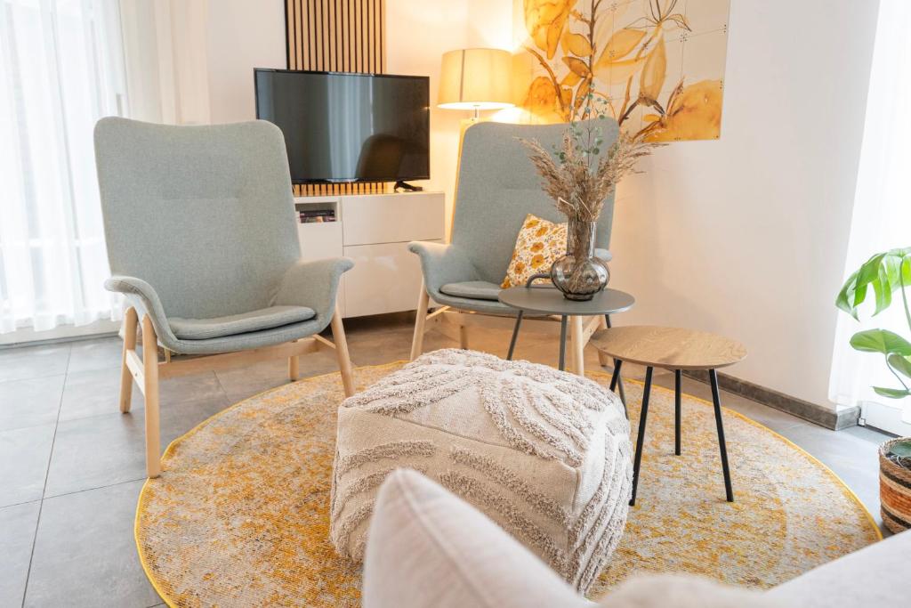 two chairs and a table in a living room at Residenz - Naturwunder - Terrasse - Sauna - Parkplatz in Bad Zwischenahn