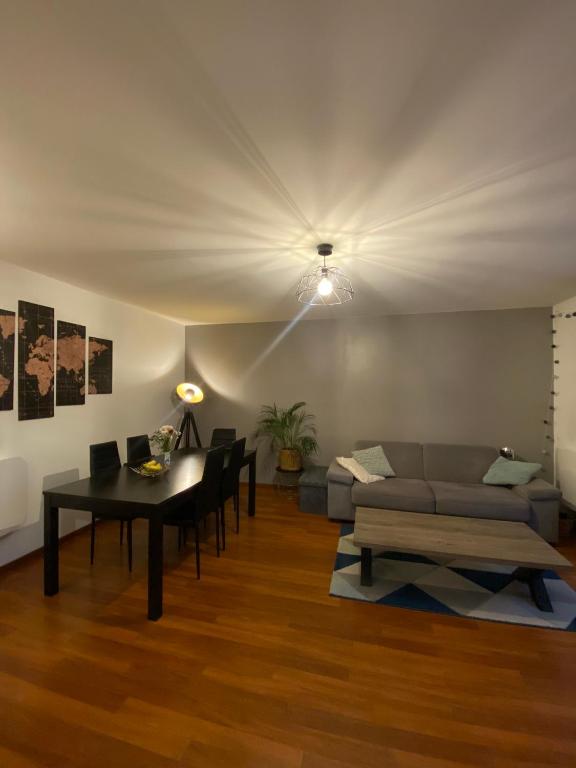 un salon avec un canapé et une table dans l'établissement Rez de jardin - JO 2024, à Plaisir