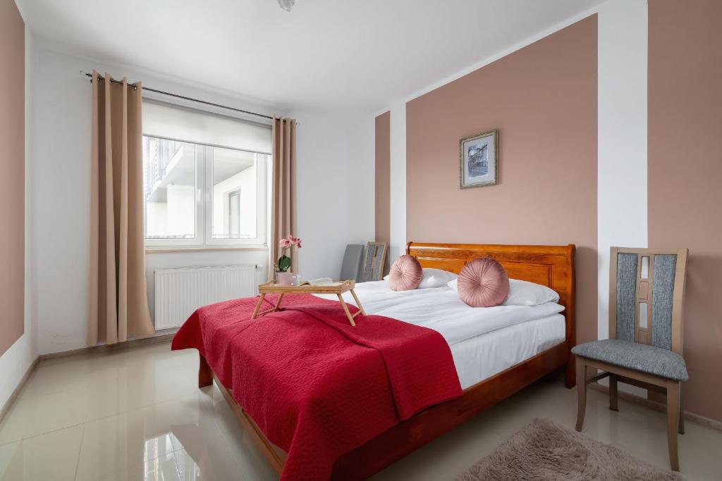 1 dormitorio con 1 cama con manta roja en Modern Apartment with Parking in Cracow by Rent like home, en Cracovia