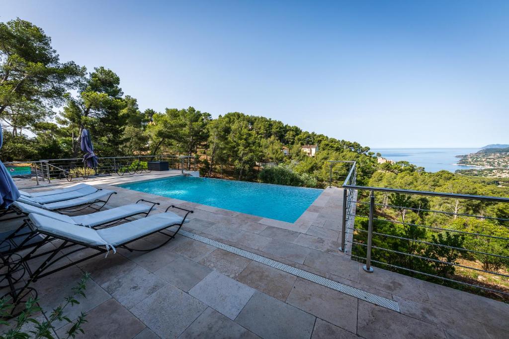 een villa met een zwembad en uitzicht op de oceaan bij Rez de Villa La Belle Californienne in Carqueiranne