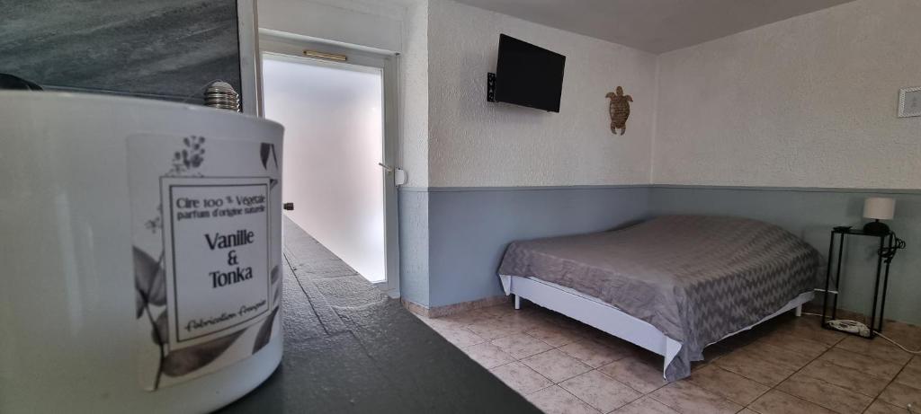 een kleine slaapkamer met een bed en een televisie bij Appartement Cosy Le Boutet in Charleville-Mézières