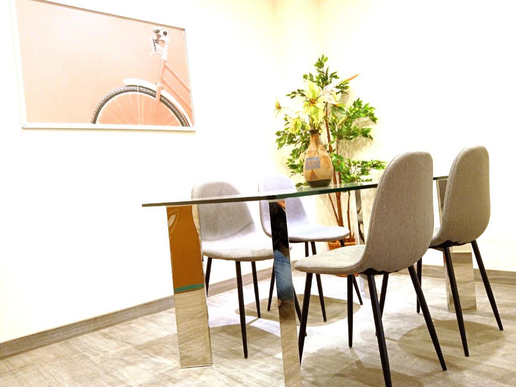 a dining room table with white chairs and a bike on the wall at Apartamento Cuzco in Trujillo
