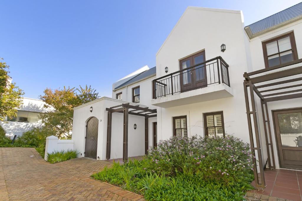 Casa blanca con balcón y entrada en Winelands Golf Lodges 24, en Stellenbosch