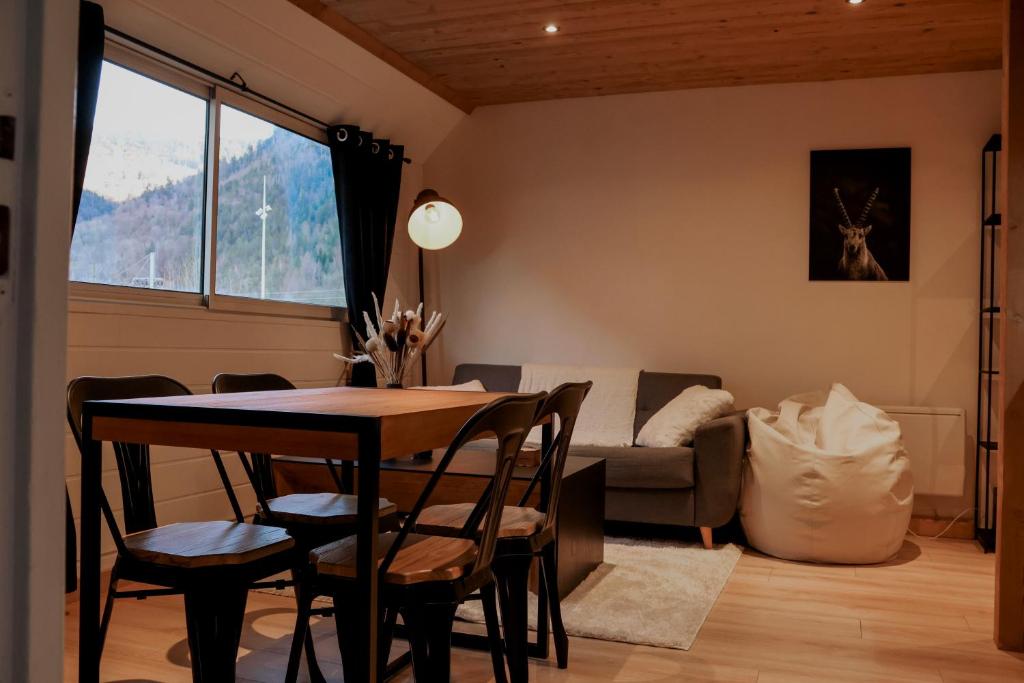 uma sala de estar com uma mesa e cadeiras e um sofá em Ambiance montagne, à deux pas de la gare em Cluses