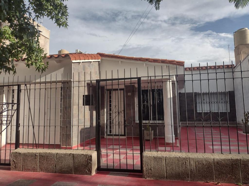 ein Gebäude mit einem Zaun davor in der Unterkunft Amplia Casa Familiar en G Cruz in Godoy Cruz