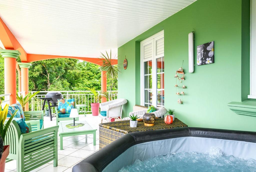 a house with a hot tub on a patio at La maison créole in Rivière-Pilote