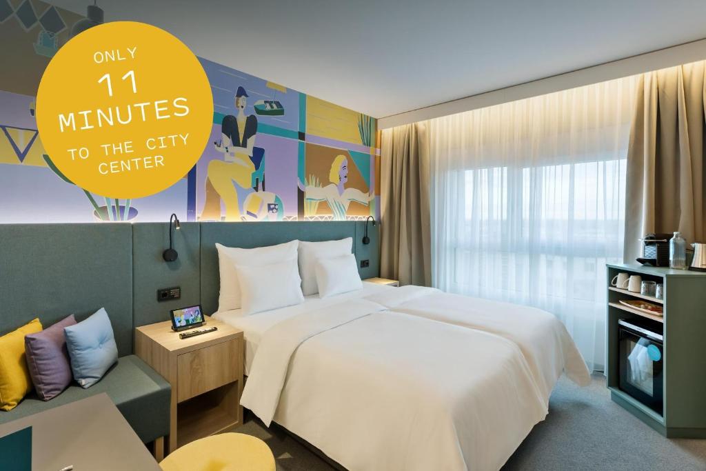 una camera d'albergo con un grande letto e un cartello di BASSENA Wien Donaustadt a Vienna