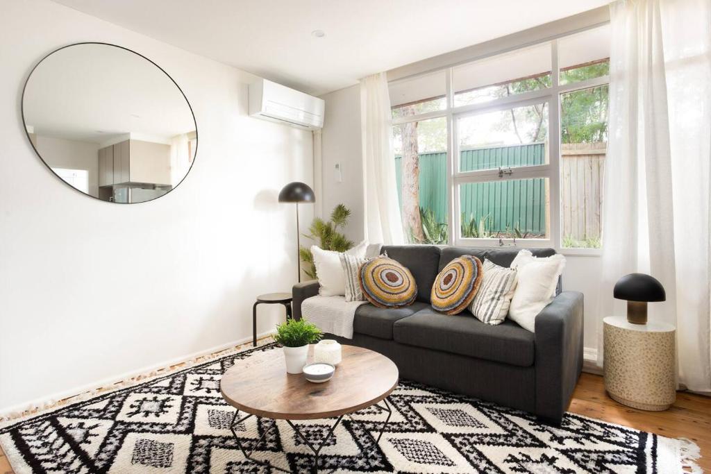 a living room with a couch and a round mirror at Live Like a Sydney Local in Trendy Marrickville in Sydney