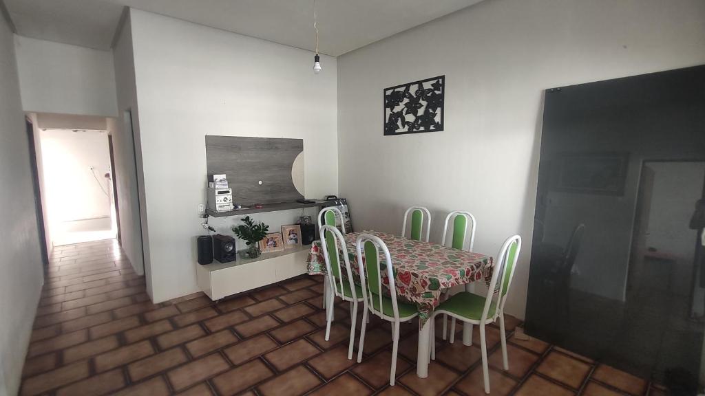 a dining room with a table and green chairs at Casa do Edivaldo in Rio de Contas