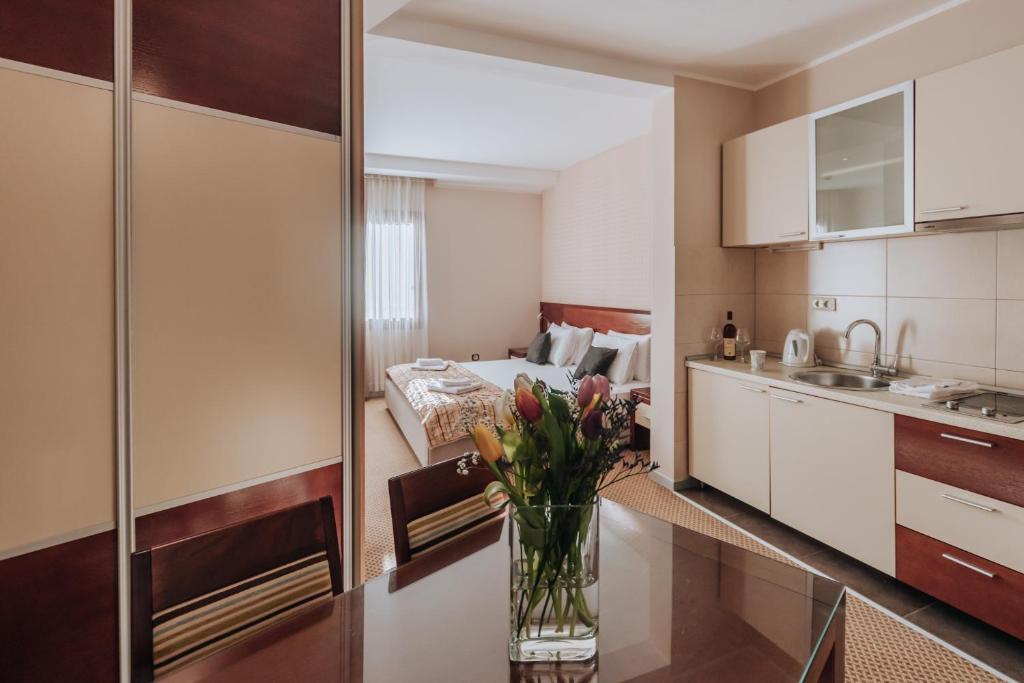 a kitchen with a vase of flowers on a table at Apartments Del Mar in Petrovac na Moru