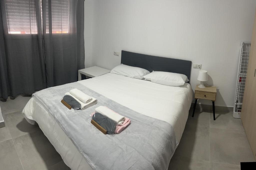 a bedroom with a large bed with two towels on it at Apartamento Tejares 2B in Málaga