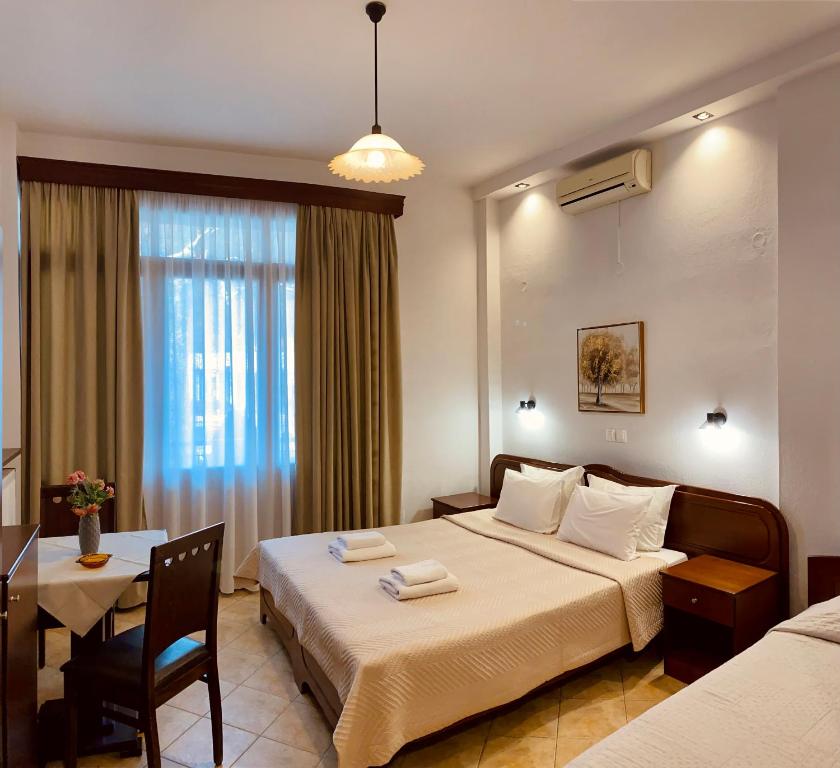 una habitación de hotel con una cama grande y una mesa en Rodon Guesthouse, en Kato Loutraki