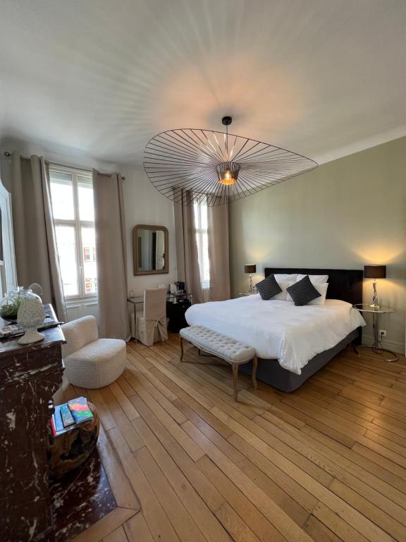 a large bedroom with a large bed and a chandelier at La Demeure des Sacres - Cathédrale in Reims
