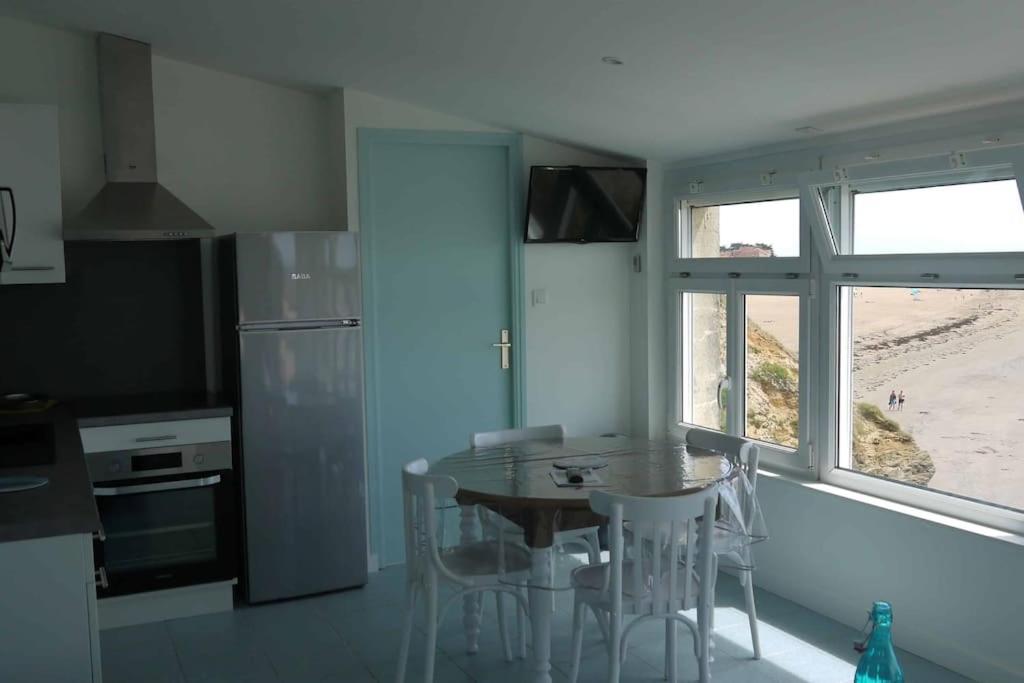 une cuisine avec une table et des chaises et une cuisine avec une plage dans l'établissement Appartement NOIRMOUTIER, à La Bernerie-en-Retz