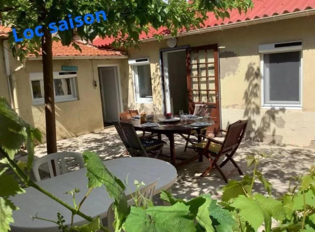 un patio avec une table et des chaises devant une maison dans l'établissement Fois Pêcheur, à Valras-Plage