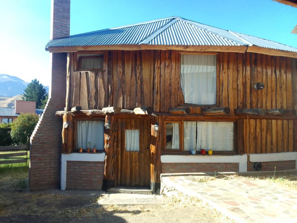 uma casa de madeira com duas janelas e uma porta em CABAÑAS EL PALENQUE em Esquel