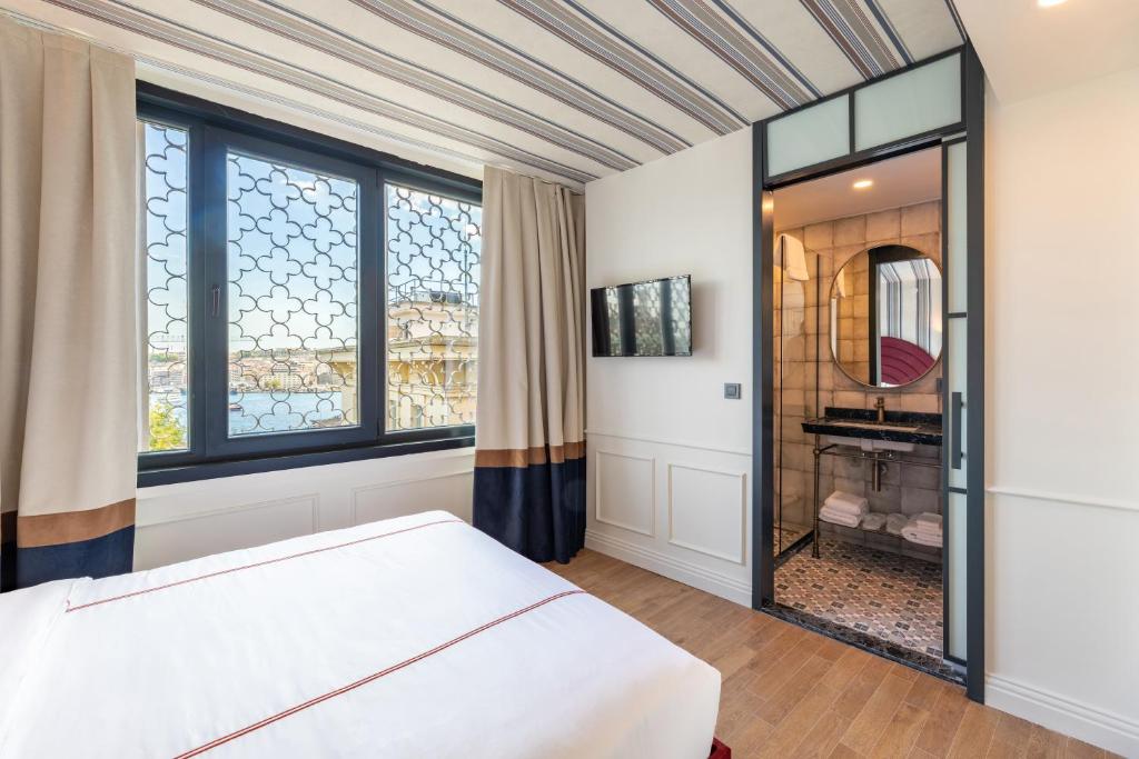 a bedroom with a bed and a large window at Khai Karaköy in Istanbul