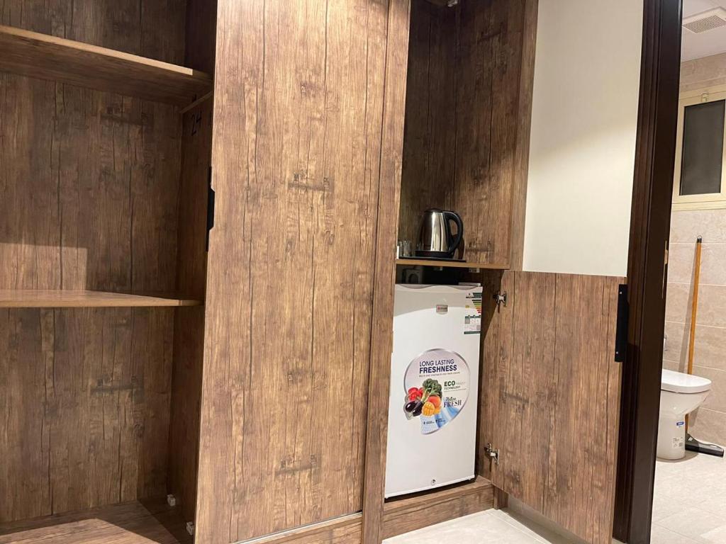 a small kitchen with a refrigerator in a room at فندق الخلفاء الماسي in Makkah