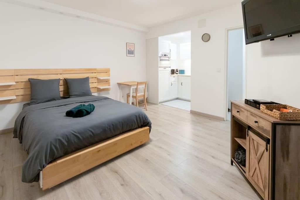 une chambre avec un grand lit et une cuisine dans l'établissement Le capucin, à Metz