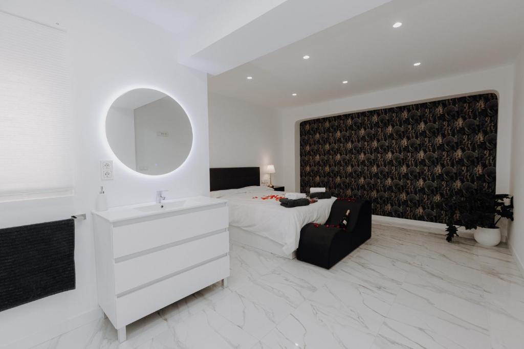 een slaapkamer met een bed, een wastafel en een spiegel bij Excapada suite de Murcia in Murcia