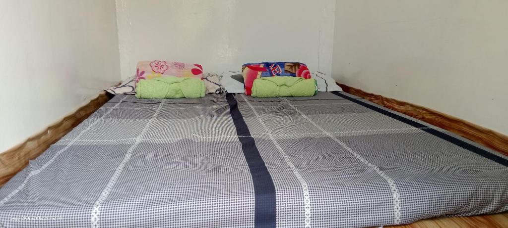 a bed in a corner of a room at Jolits Ecogarden Integrated Farm in Batuan
