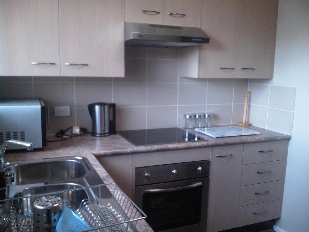 a kitchen with a sink and a stove at Grey Pebbles in Nowra