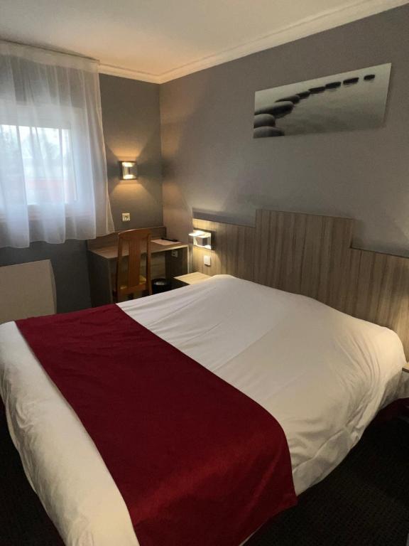 ein Schlafzimmer mit einem großen weißen Bett mit einer roten Decke in der Unterkunft initial by balladins Amiens / Longueau in Longueau