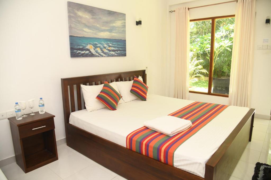 a bedroom with a large bed with a window at wild park safari home stay in Udawalawe
