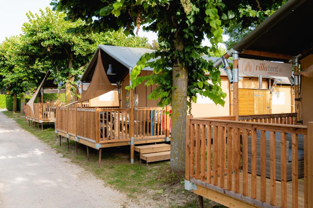 a group of wooden lodges with a tree at Glamping Bretagne in Quimper