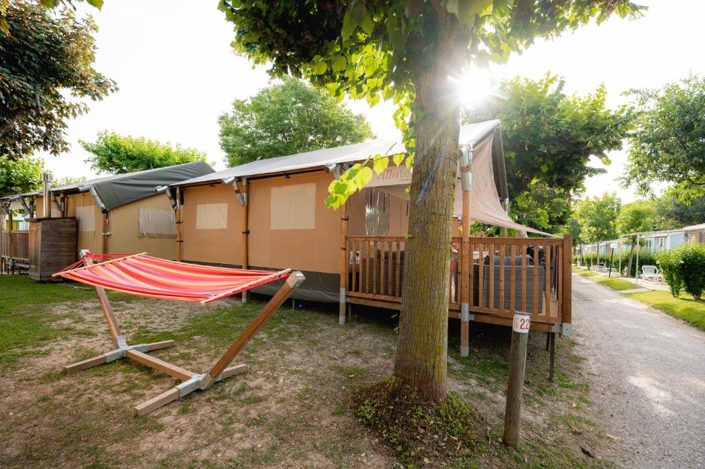 a house with a hammock next to a tree at Glamping Bretagne in Quimper