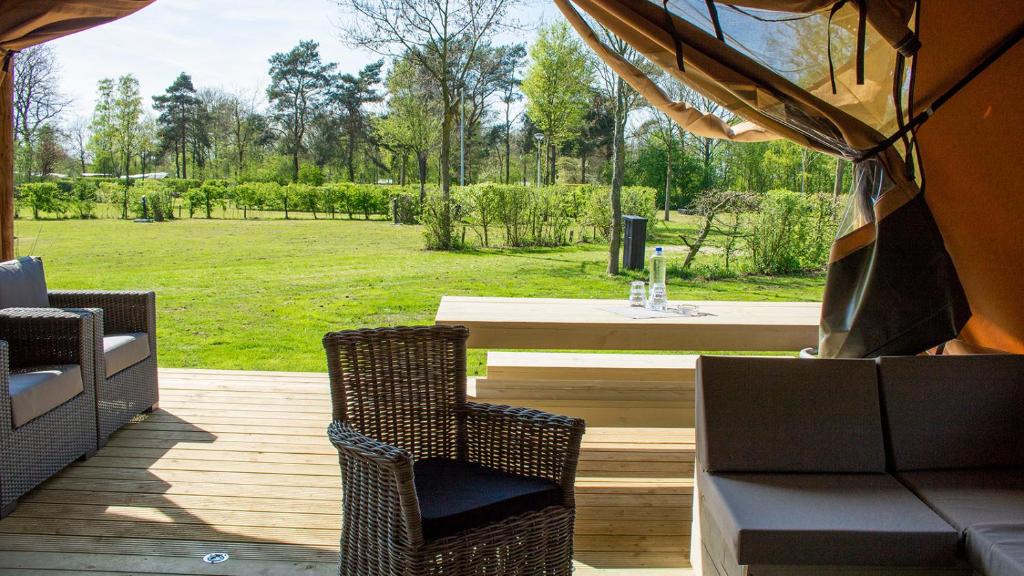 a patio with a table and chairs and a field at Glamping Bretagne in Quimper
