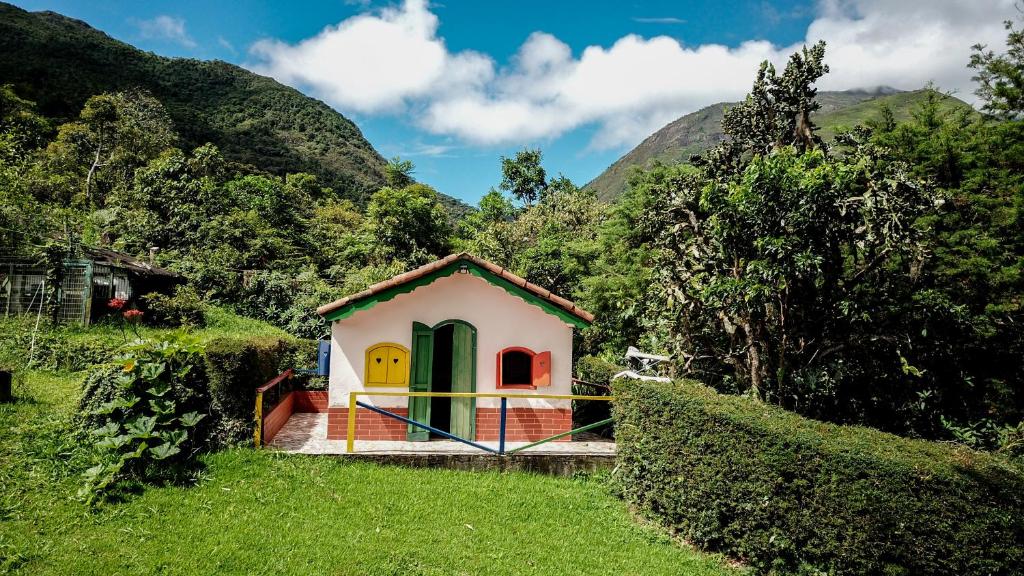 a small house with a green door on a hill at Canto dos Pássaros in Nova Friburgo
