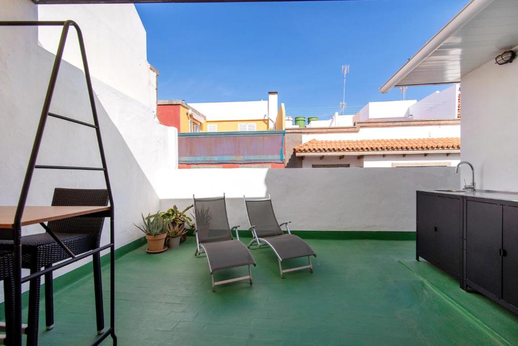 a patio with chairs and a table on a building at Apto Tatiana - Casa San Marcial in Las Palmas de Gran Canaria