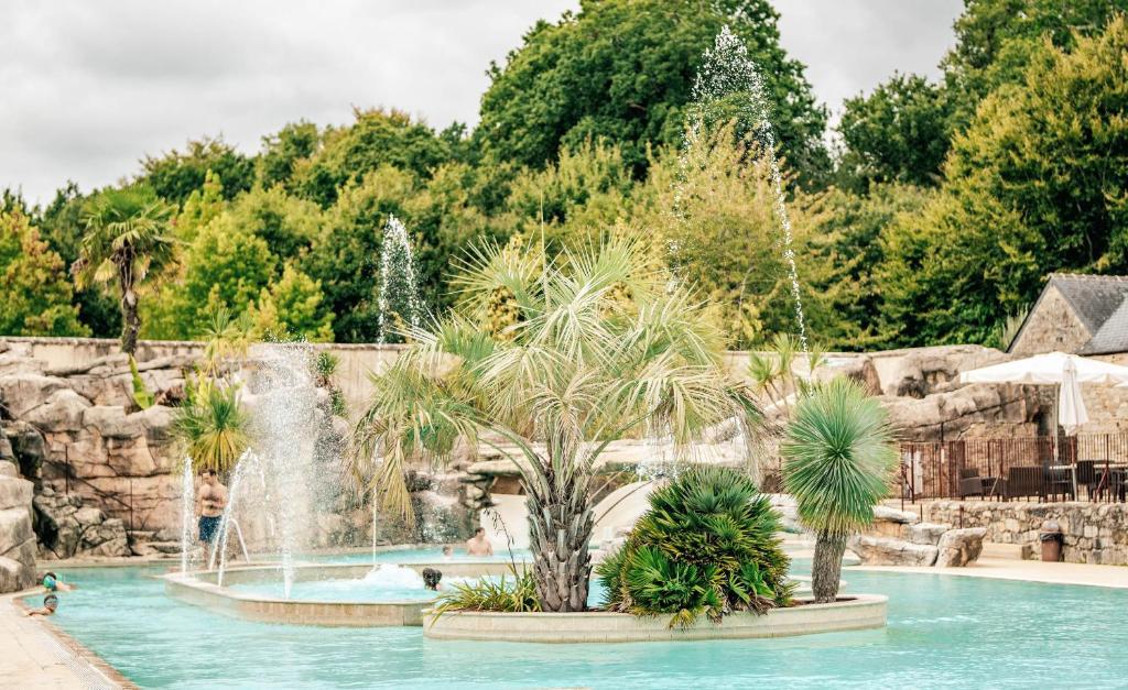 a swimming pool with a waterfall in a resort at Glamping Bretagne in Quimper