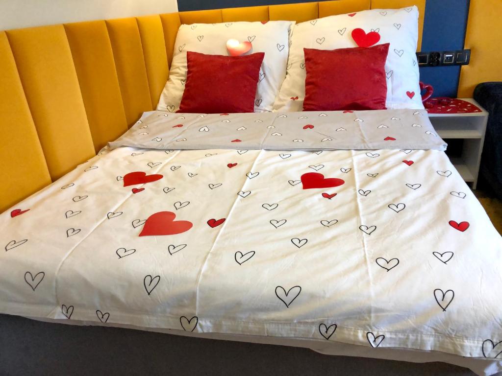 a bed with red pillows and hearts on it at Golden Luxury Suite in Nowy Dwór Mazowiecki