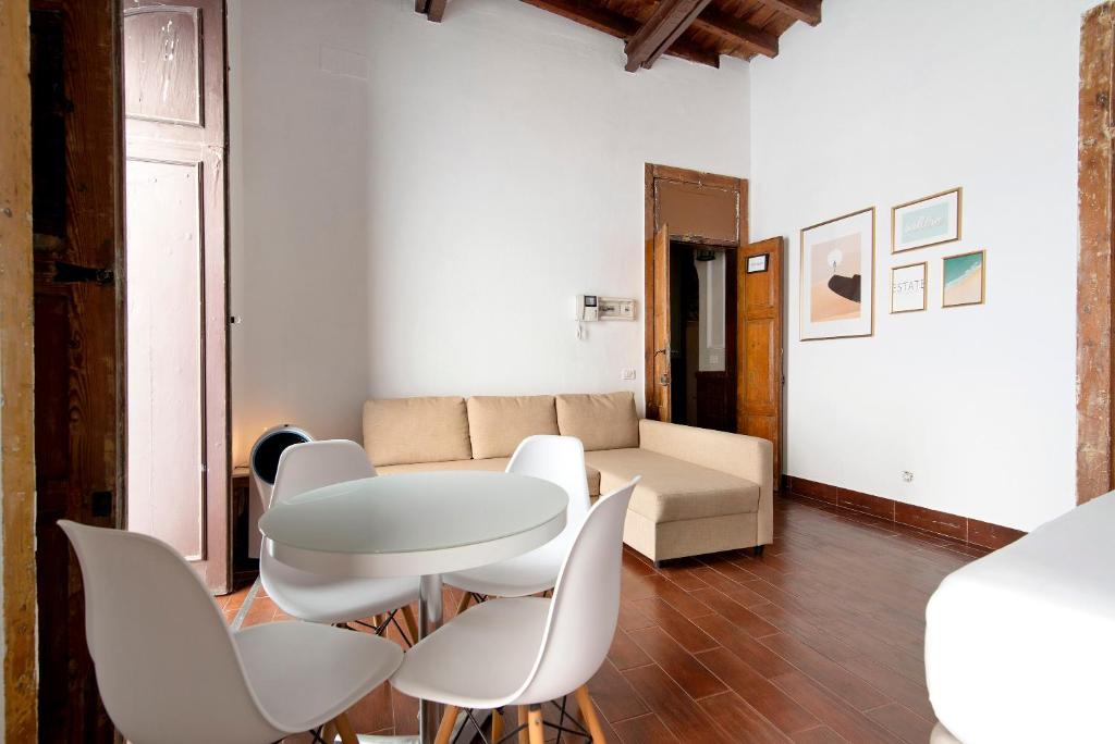 un soggiorno con tavolo e sedie bianche di Apto Don Pepe - Casa San Marcial a Las Palmas de Gran Canaria