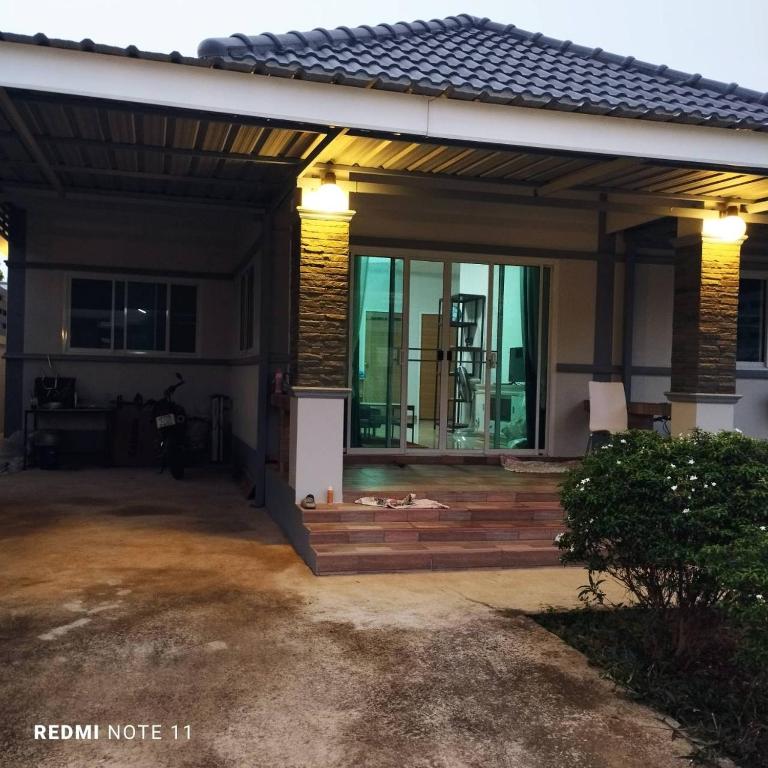 a house with a large patio with a deck at Bann Sukjai in Kanchanaburi City