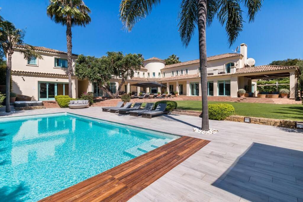 een groot huis met een zwembad en palmbomen bij 7 Room Villa Mansion - Sleeps 16+ in San Roque