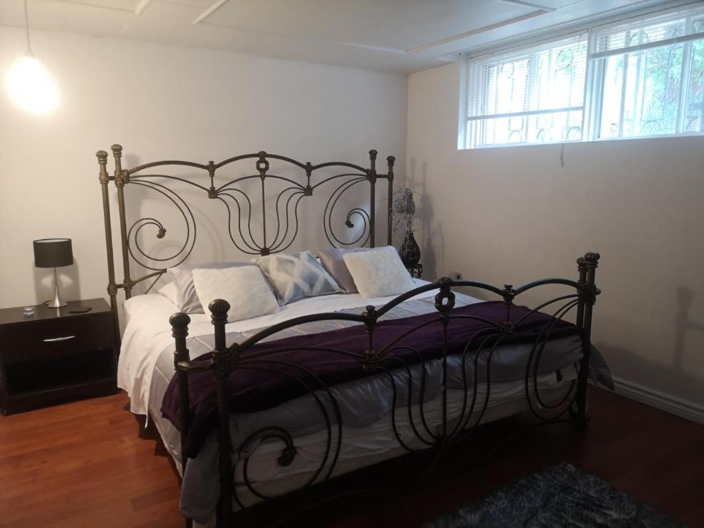 モントリオールにあるComfortable 2-bedroom, private kitchen and bathroomのベッドルーム1室(大型ベッド1台、白いシーツ、枕付)