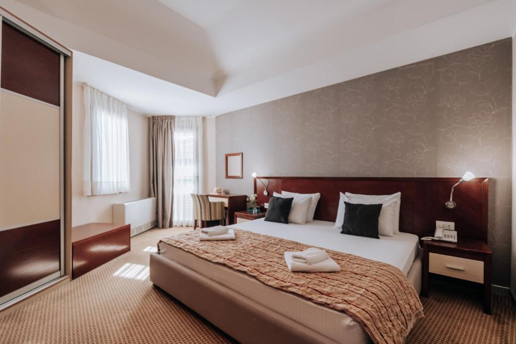 a hotel room with a bed with two towels on it at Apartments Del Mar in Petrovac na Moru