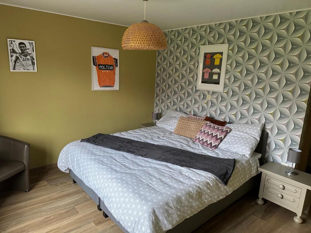 a bedroom with a bed with a gray headboard at 't Coureurke in Brakel